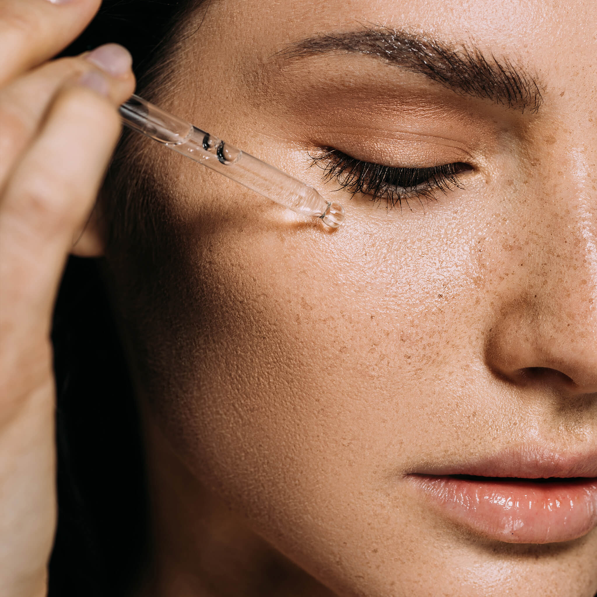 Close up image of a woman applying skincare on her face at an aesthetic skin clinic in sydney