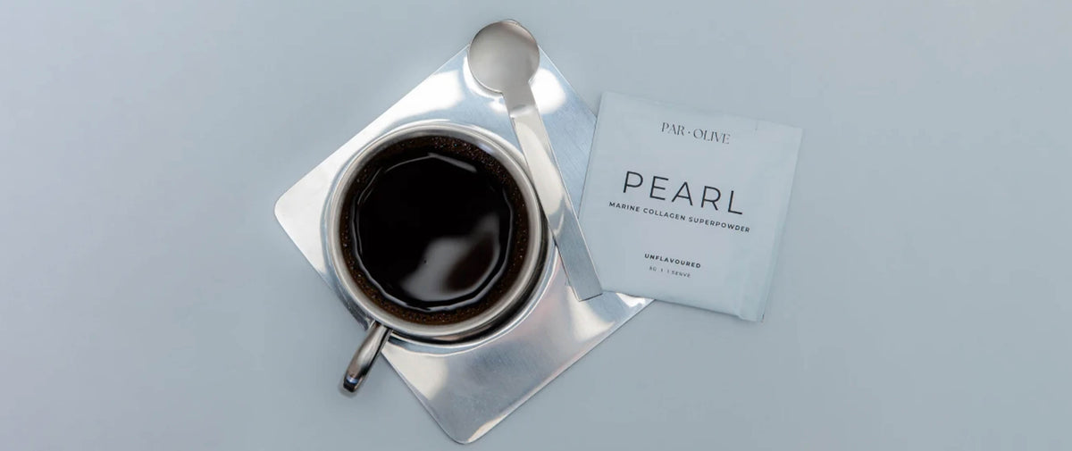 A top-down view of a silver cup of black coffee on a square silver saucer with a spoon, next to a white Par-O-Nit PEARL warm collagen supplement packet, on a light gray background.